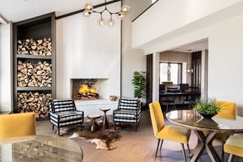 A living room with a fireplace and a table and chairs